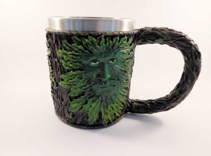 A tankard showing a greenman face (in green) against a brown bark background - the handle is a twisted branch
