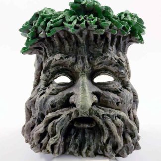 The front view - a mans face created with branches, his hair green leaves, his eyes are hollow to see the candle flickering in the back