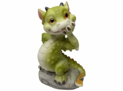 Cute little green dragon with a paw over its mouth