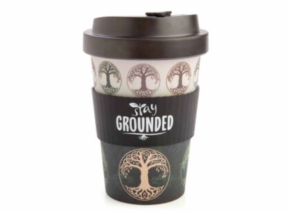 A large travel mug with black lid. The tree of life symbol is repeated around the top in brown and green against a cream background. The black silicon grip has the words stay grounded written in white lettering.